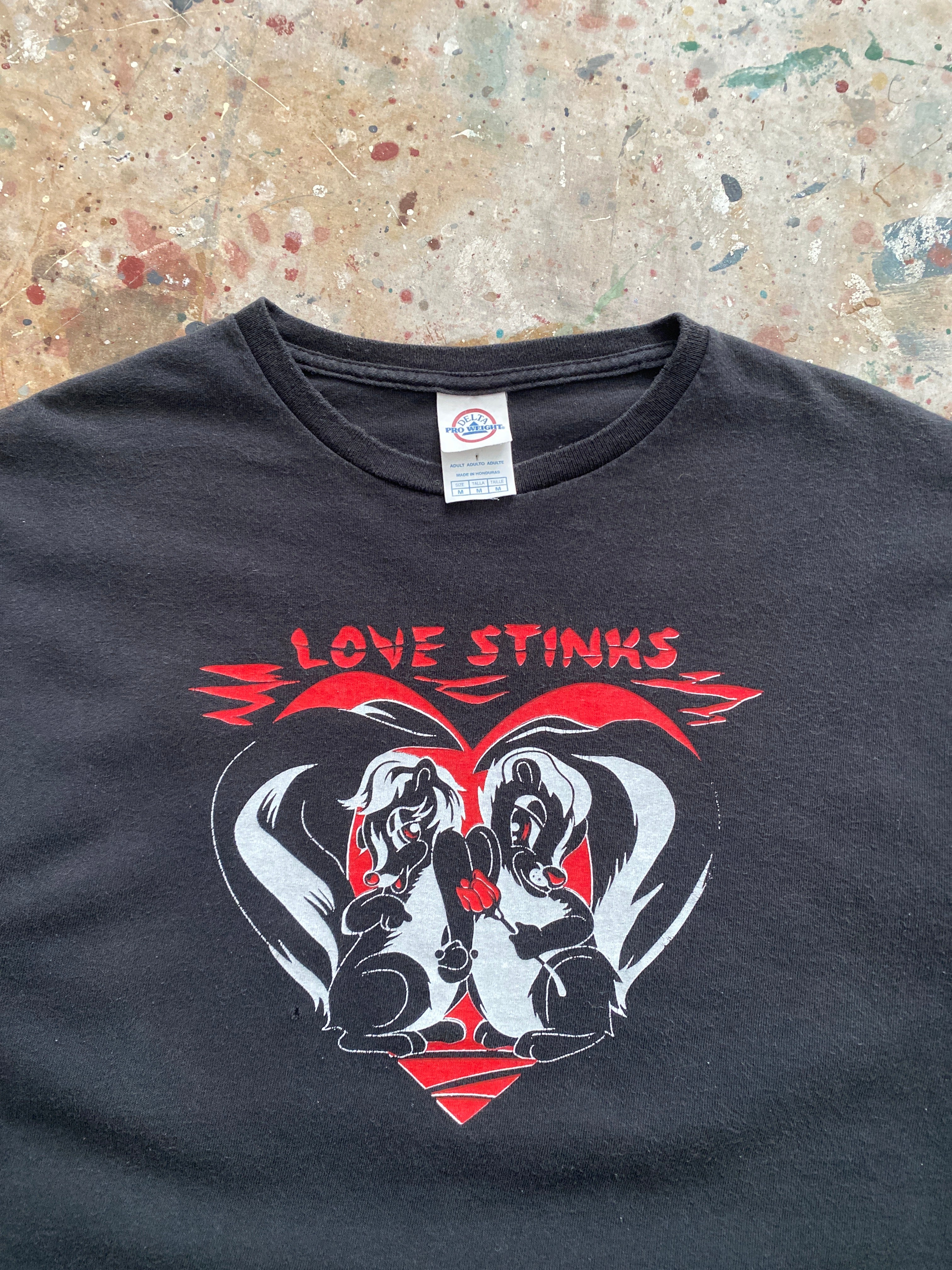 00s faded black "love stinks" skunk tee